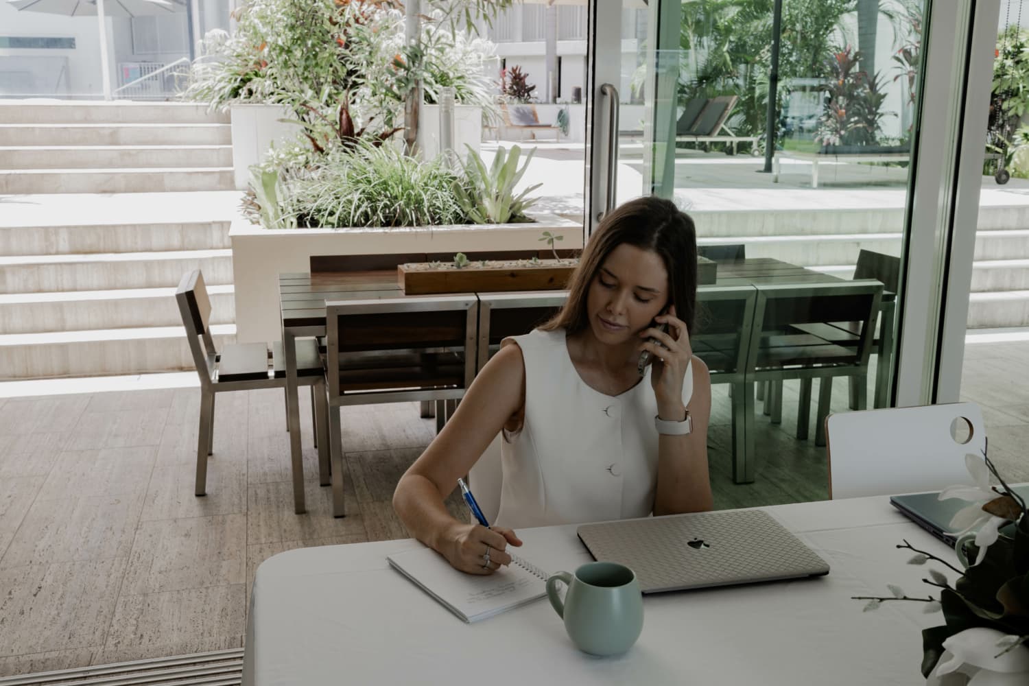 Modern meeting room at Lanai Riverside Apartments Mackay, set up for business use with conference table, chairs, and presentation screen.