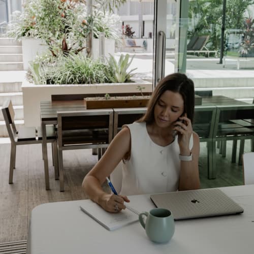 Modern meeting room at Lanai Riverside Apartments Mackay, set up for business use with conference table, chairs, and presentation screen.